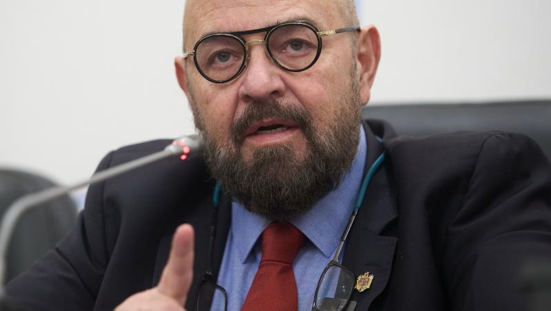 Piedone îmbrăcat cu un costum negru, la o conferință de presă