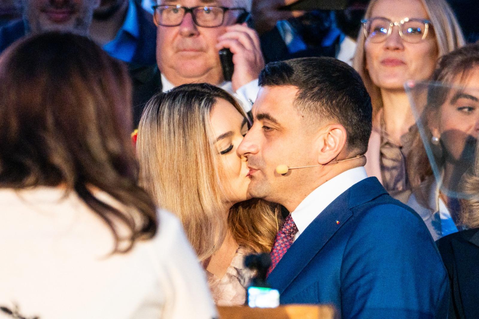 George Simion îmbrăcat cu un costum bleumarin, sarutându-și soția