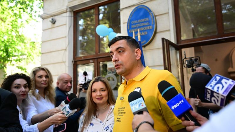 George Simion îmbrăcat cu un tricou galben, vorbind cu mai mulți jurnaliști