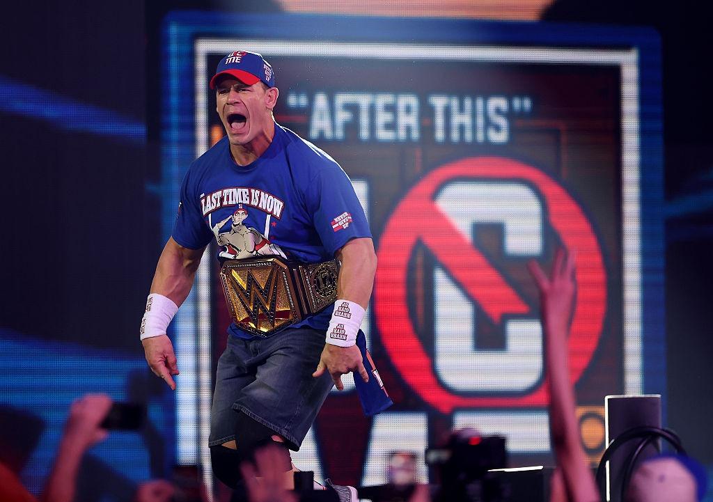 John Cena purtând centura WWE în ringul de luptă, aclamat de fani