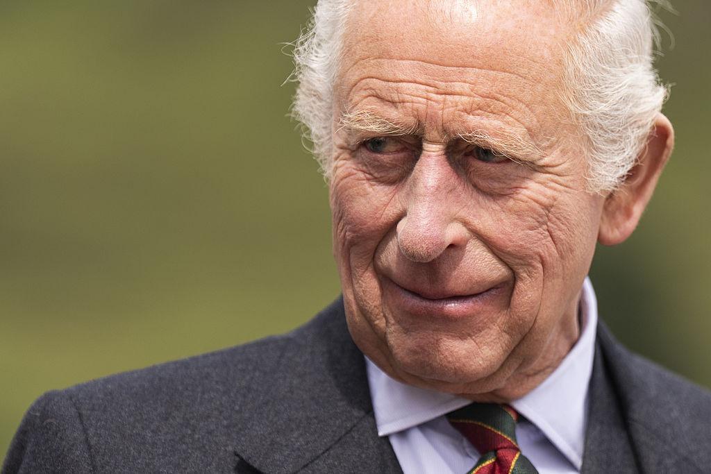 Regele Charles îmbrăcat cu un costum gri