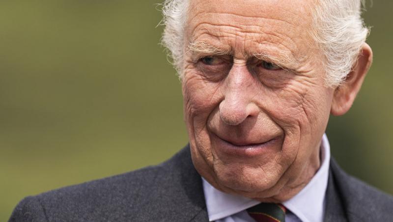 Regele Charles îmbrăcat cu un costum gri