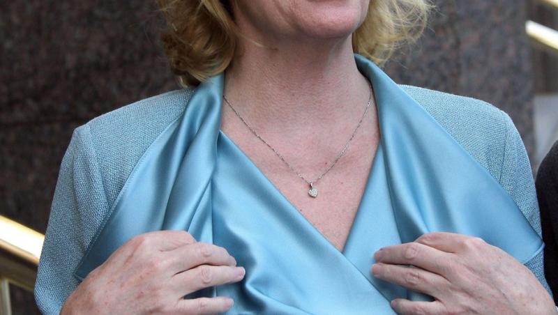 Cybill Shepherd îmbrăcată într-o ținută complet albastră, accesorizată cu ochelari de soare