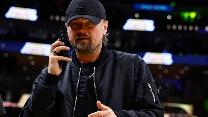 Leonardo DiCaprio îmbrăcat într-o ținută casual neagră, vorbind la telefon