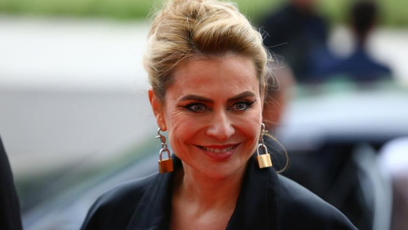 Adina Buzatu îmbrăcată cu un sacou negru și cercei în formă de lacăt