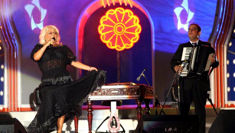 Mirabela Dauer îmbrăcată într-o ținută neagră, cântând pe scenă