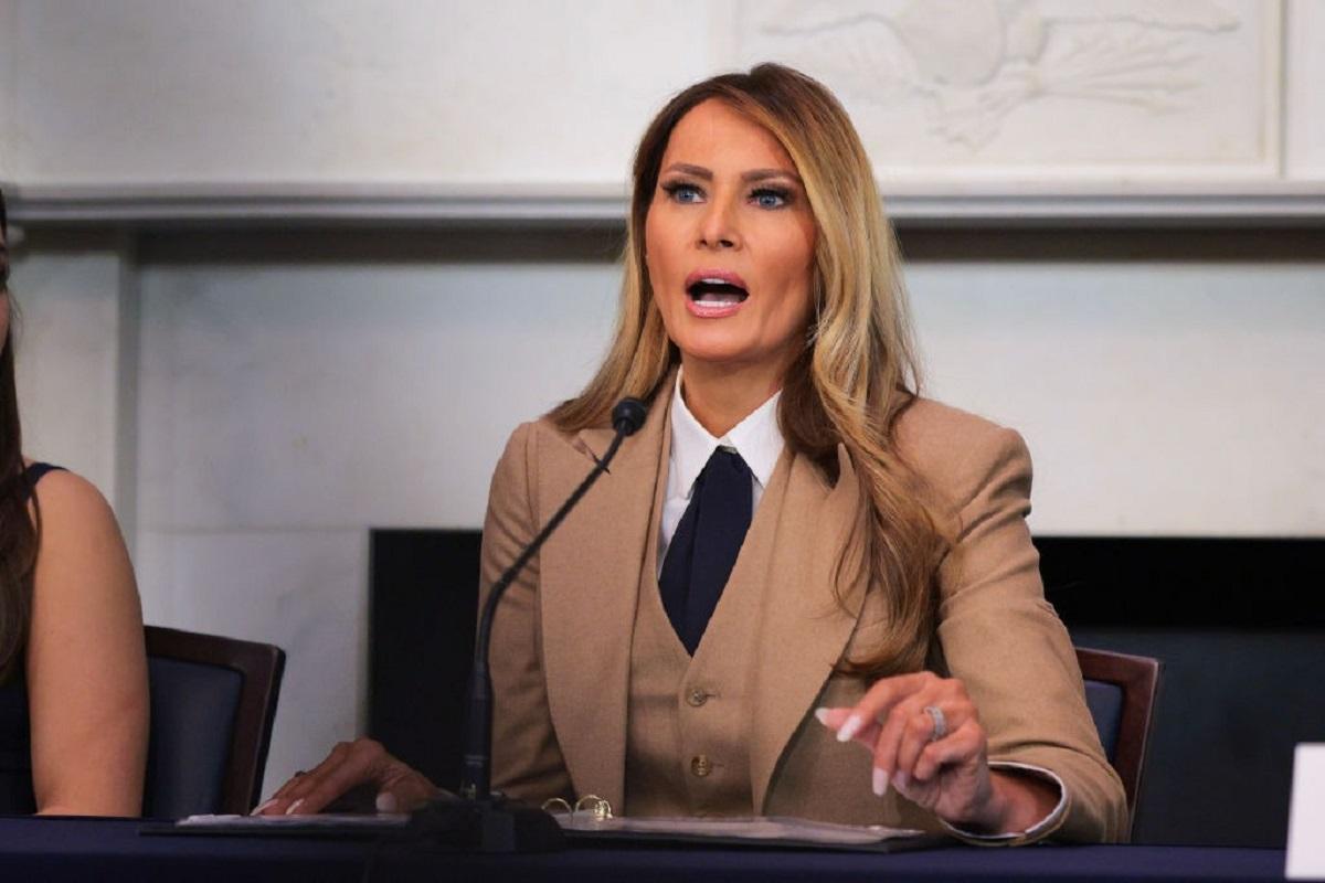 Melania Trump îmbrăcată cu un costum bej elegant, vorbind la microfon