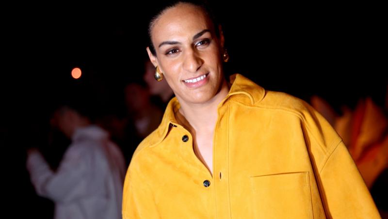 Imane Khelif îmbrăcată într-o cămașă galben muștar, cu cercei de aur