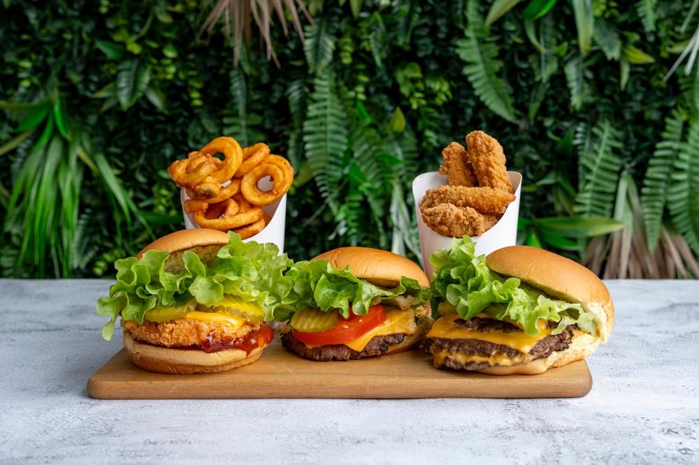 trei burgeri pe un platou