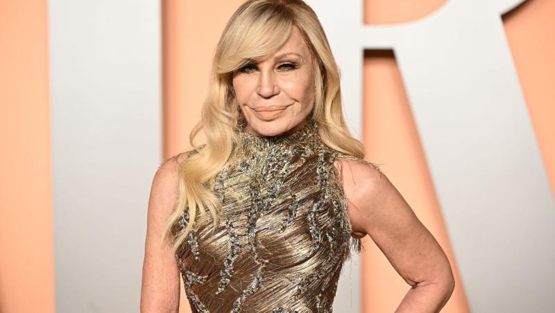 Donatella Versace îmbrăcată într-o rochie aurie strălucitoare