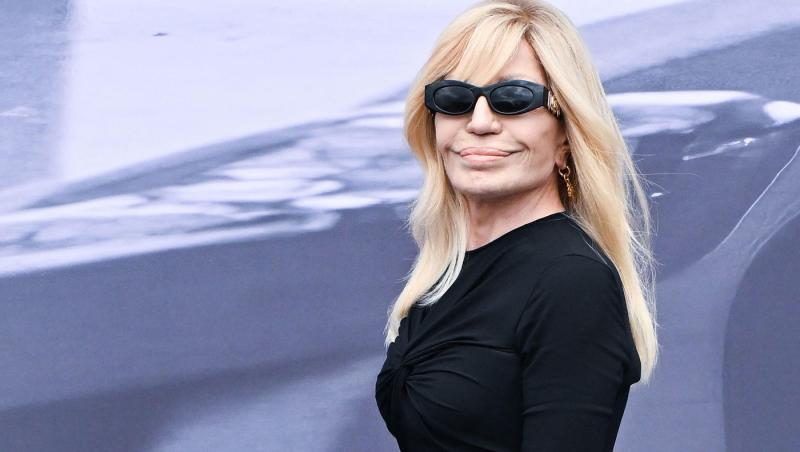 Donatella Versace îmbrăcată în negru, purtând ochelari de soare