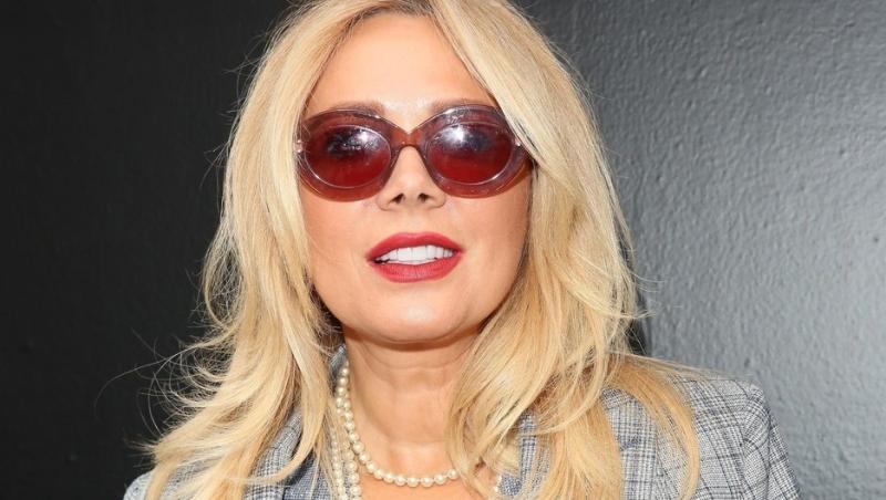 Dana Săvuică îmbrăcată într-un costum gri în carouri