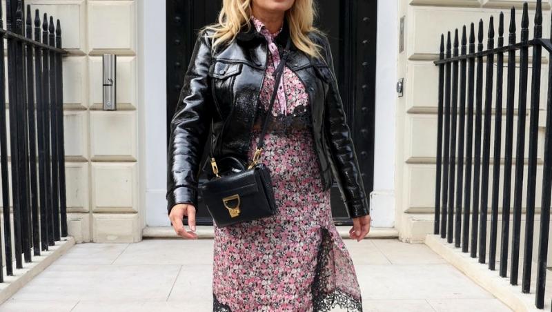 Dana Săvuică îmbrăcată într-o rochie cu imprimeu floral și o jachetă neagră din piele