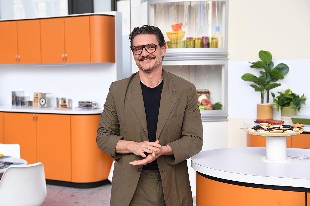Pedro Pascal îmbrăcat într-un costum maro peste o bluză neagră