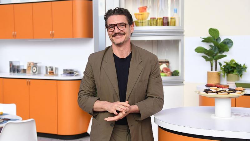 Pedro Pascal îmbrăcat într-un costum maro peste o bluză neagră