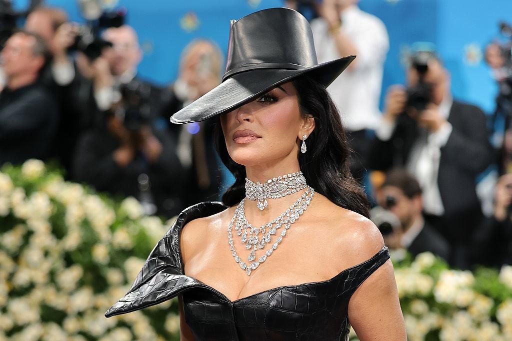 Kim Kardashian îmbrăcată cu o ținută neagră din piele și o pălărie asortată