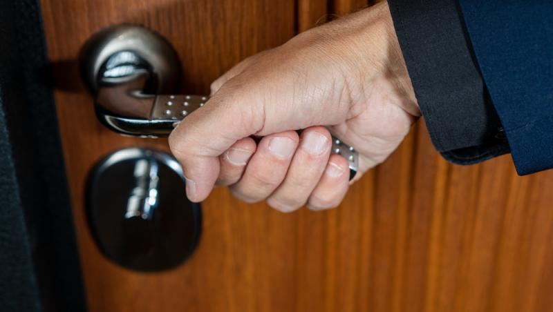 mana unui barbat care deschide usa