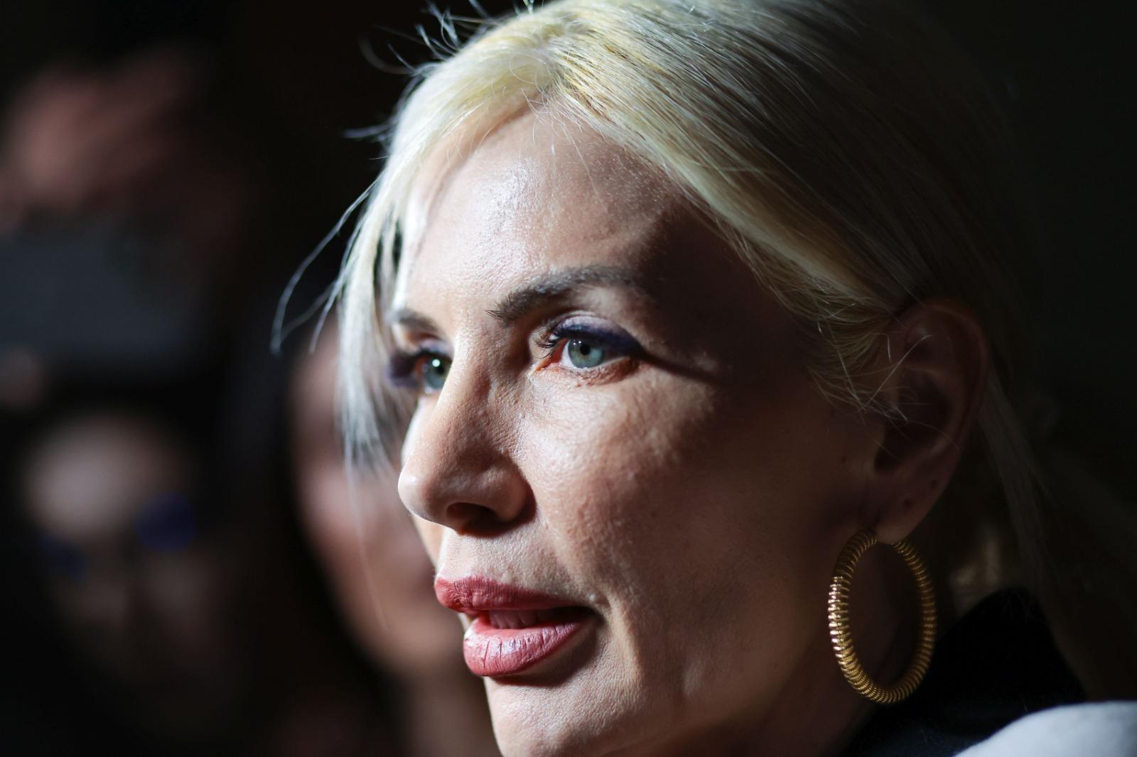 Laura Vicol îmbrăcată cu un palton gri, peste o cămașă neagră