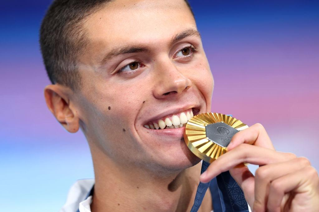 David Popovici mușcând dintr-o medalie de aur