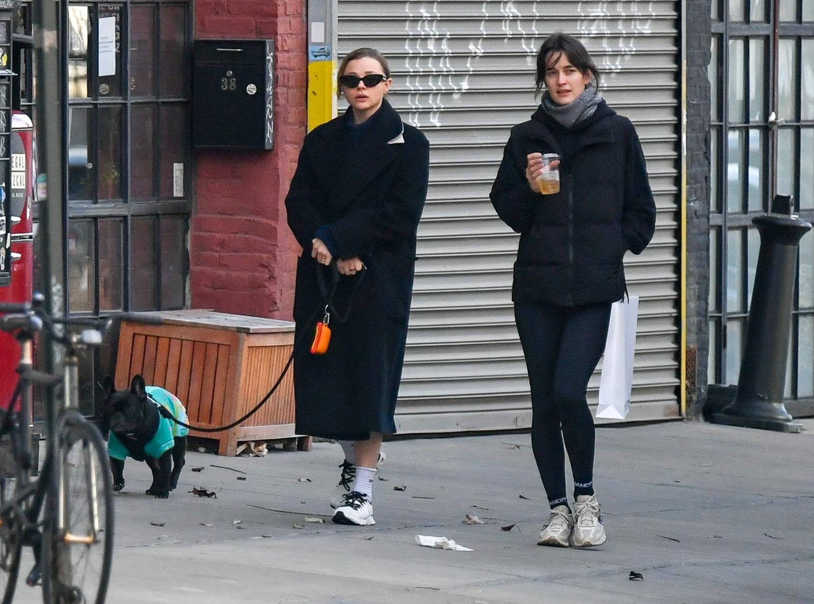 Chloë Grace Moretz îmbrăcată într-o ținută neagră, mergând pe stradă alături de Kate Harrison