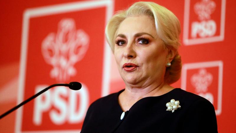 Viorica Dăncilă îmbrăcată într-o ținută neagră, vorbind la microfon
