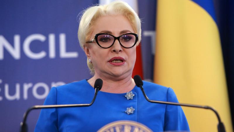 Viorica Dăncilă îmbrăcată într-o ținută albastră, vorbind la microfon