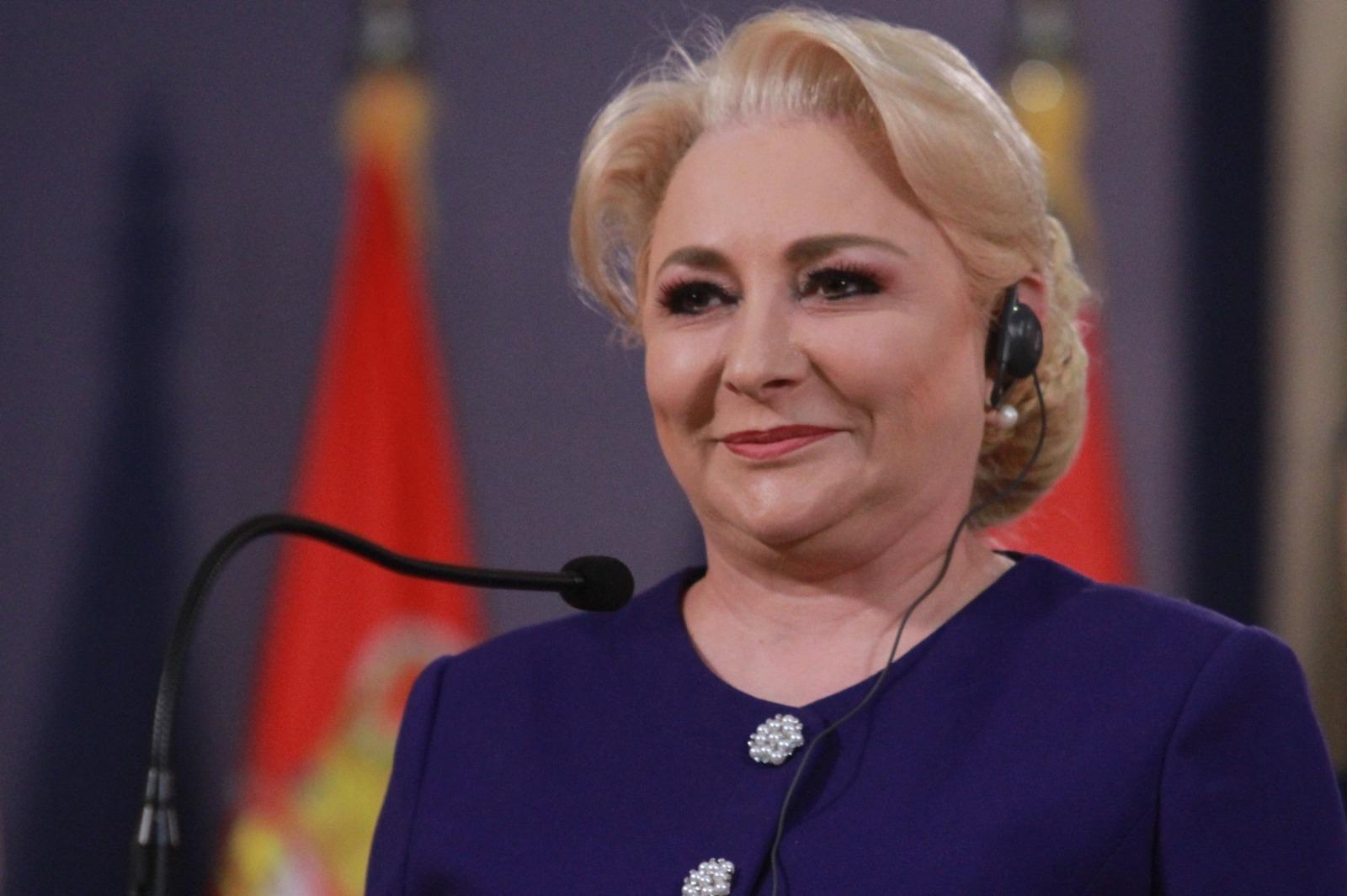 Viorica Dăncilă îmbrăcată într-o ținută bleumarin, vorbind la microfon