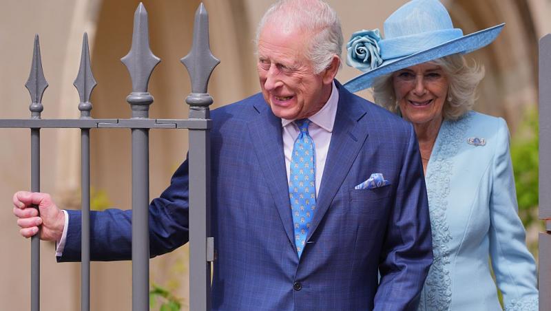 Regele Charles alături de Regina Camilla, îmbrăcați în ținute elegante, zâmbind