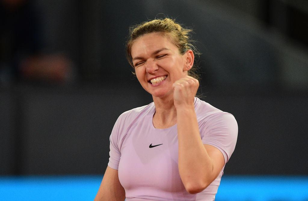Simona Halep îmbrăcată cu un tricou mov, jucând tenis