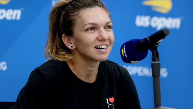 Simona Halep îmbrăcată cu o bluză neagră, la o conferință de presă