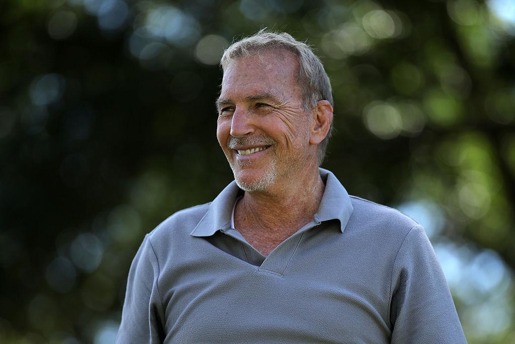 Kevin Costner îmbrăcat cu un un tricou Polo gri