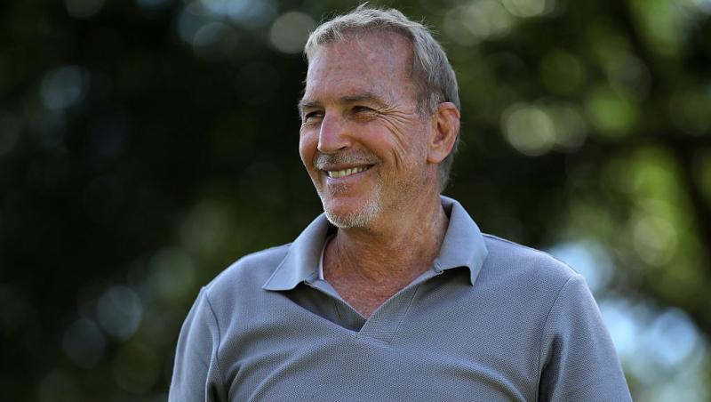 Kevin Costner îmbrăcat cu un un tricou Polo gri