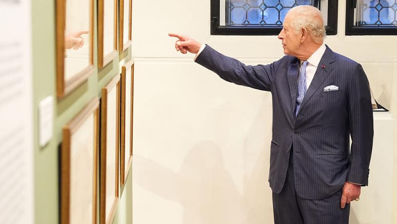 regele charles arătând spre un tablou la expoziția dedicată reginei maria a româniei de la londra
