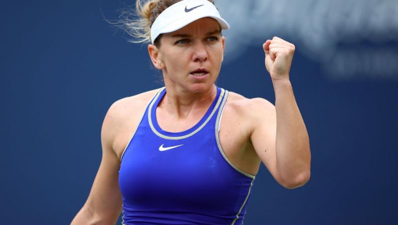 Simona Halep îmbrăcată cu un top albastru, jucând tenis