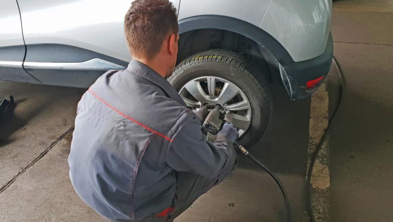 imagine cu barbat care schimba cauciurile de vara cu cele de iarna