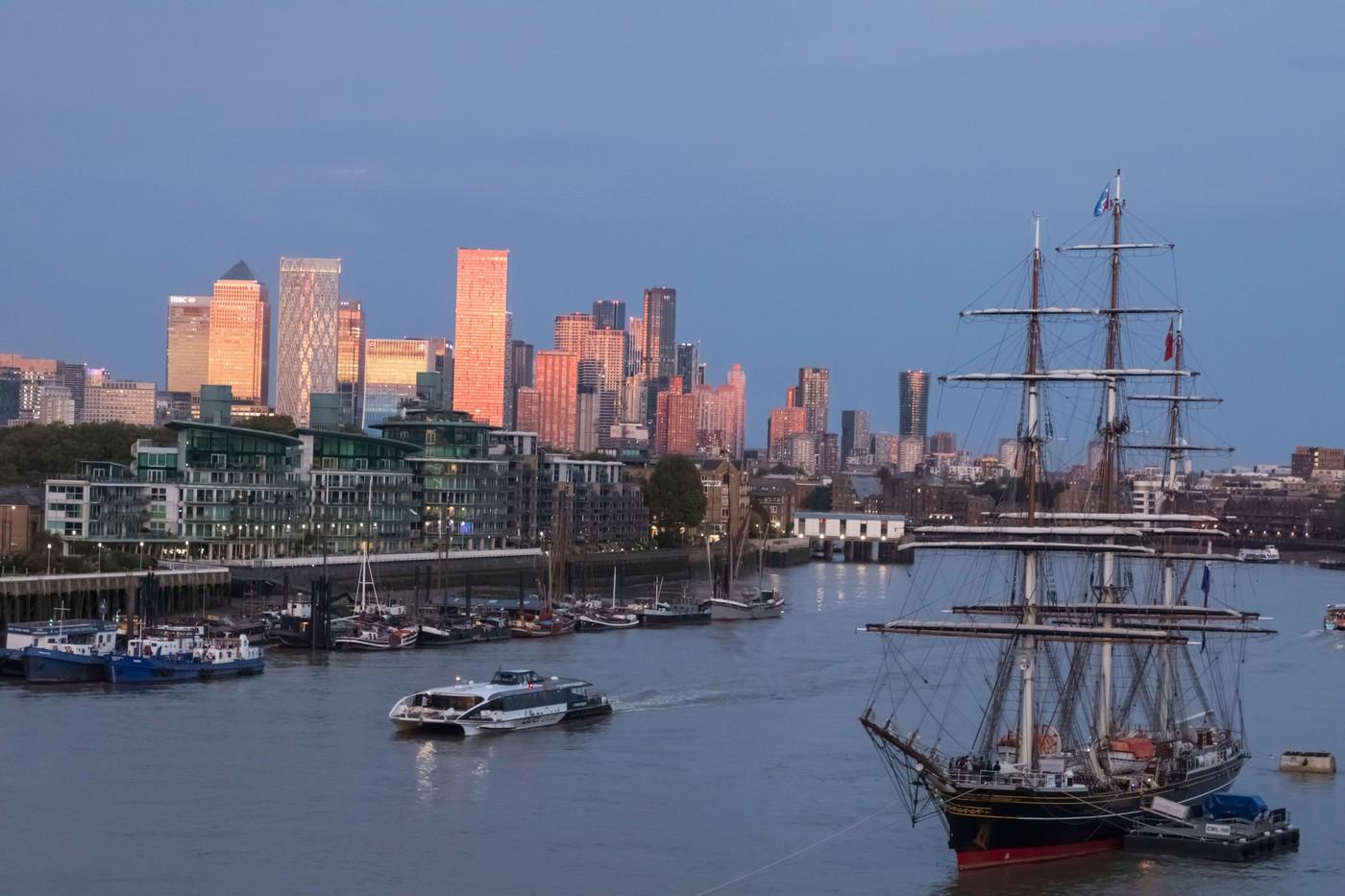 Anglia, Londra, Greenwich, râul Tamisa și orizontul cartierului Canary Wharf, cu vasul olandez „Stad Amsterdam” în lumina sfârșitului de după-amiază