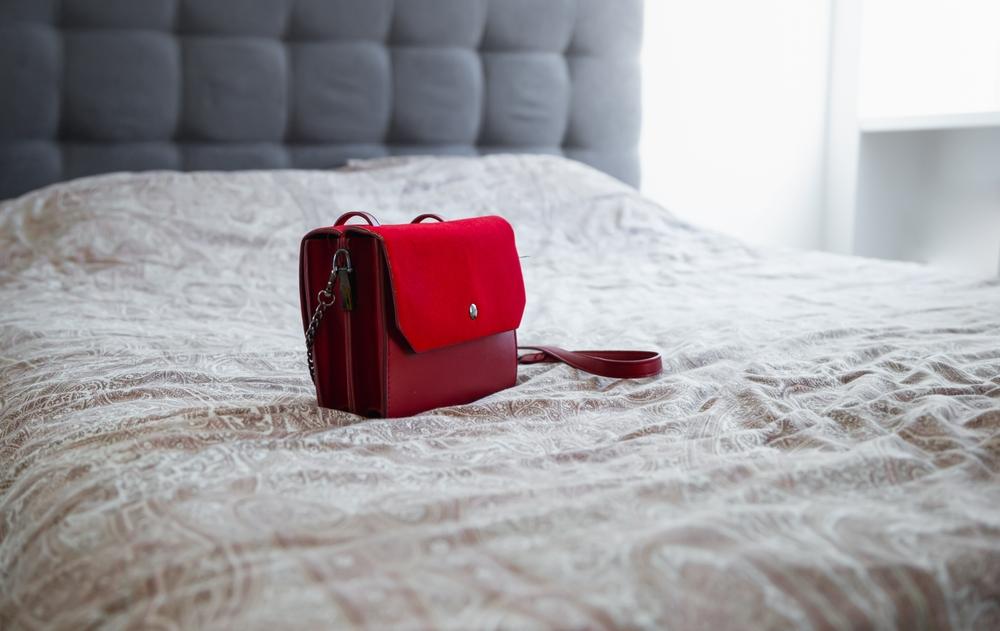 imagine cu o geanta rosie pe pat