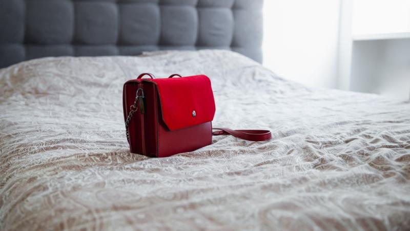 imagine cu o geanta rosie pe pat