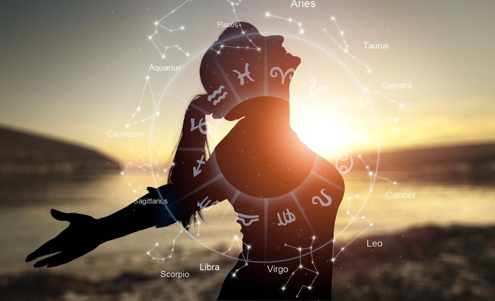 femeie fericita cu bratele intinse si cercul celor 12 zodii din horoscop