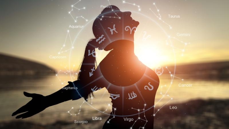 femeie fericita cu bratele intinse si cercul celor 12 zodii din horoscop