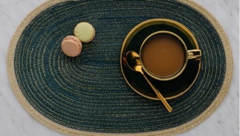 imagine cu un napron verde cu o ceasca pe el si niste macarons