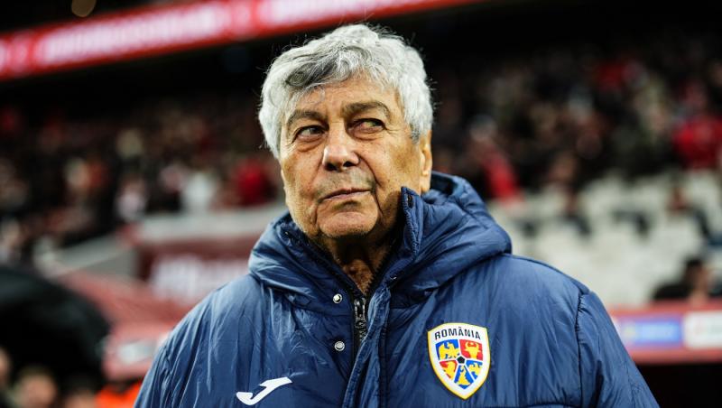 Mircea Lucescu poartă o geacă albastră pe un fundal deschis