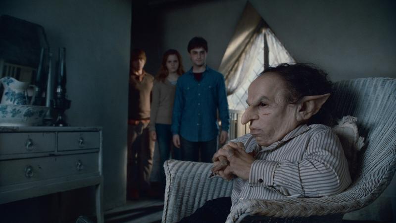 actorul din harry potter stă pe scaun pe un fundal &icirc;nchis la culoare