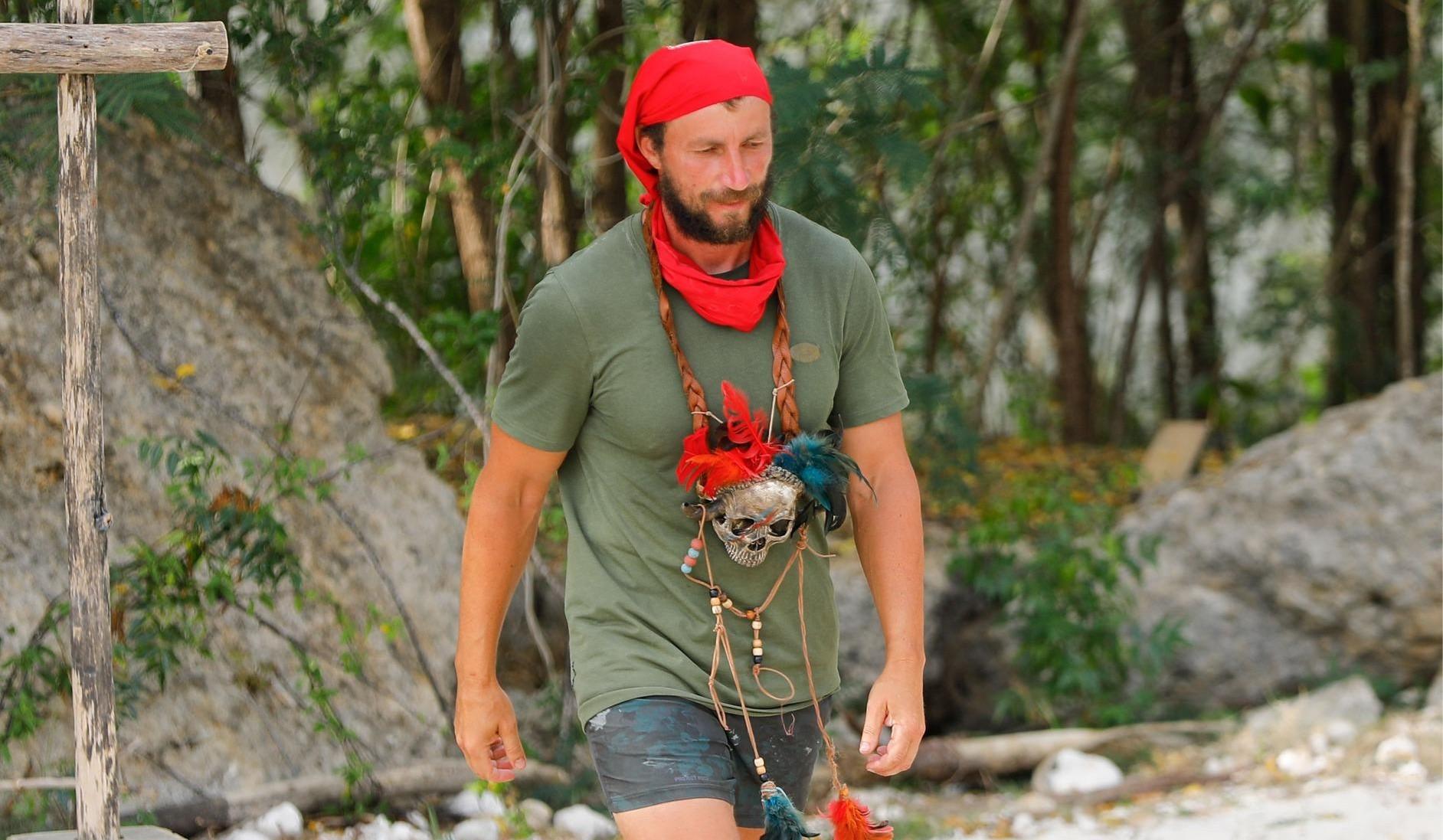 Marian Godină în tricou kaki și cu bandană roșie pe cap și la gât