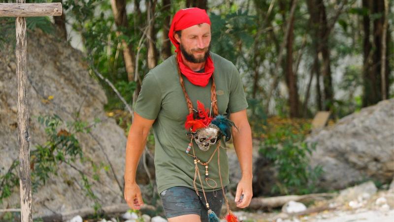 Marian Godină &icirc;n tricou kaki și cu bandană roșie pe cap și la g&acirc;t