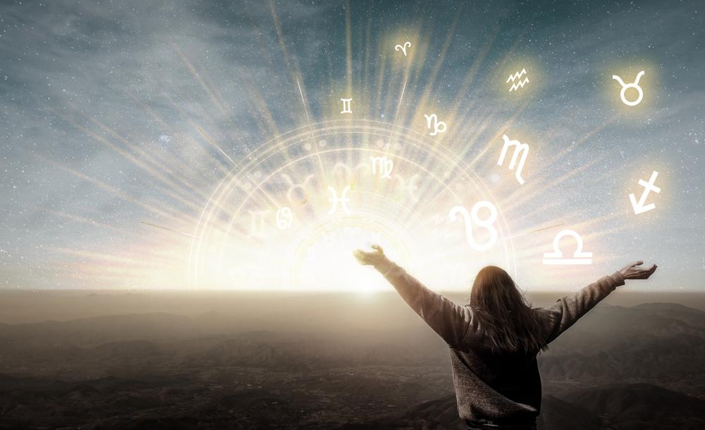 femeie cu mainile ridicate la cer si cercul celor 12 zodii