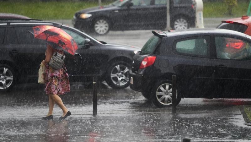 O femeie cu o umbrelă pe vreme ploioasă