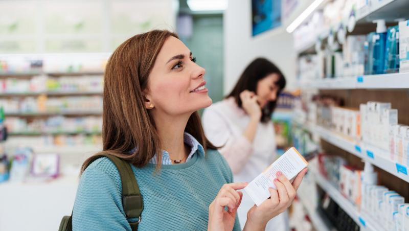 femeie care caută &icirc;n farmacie