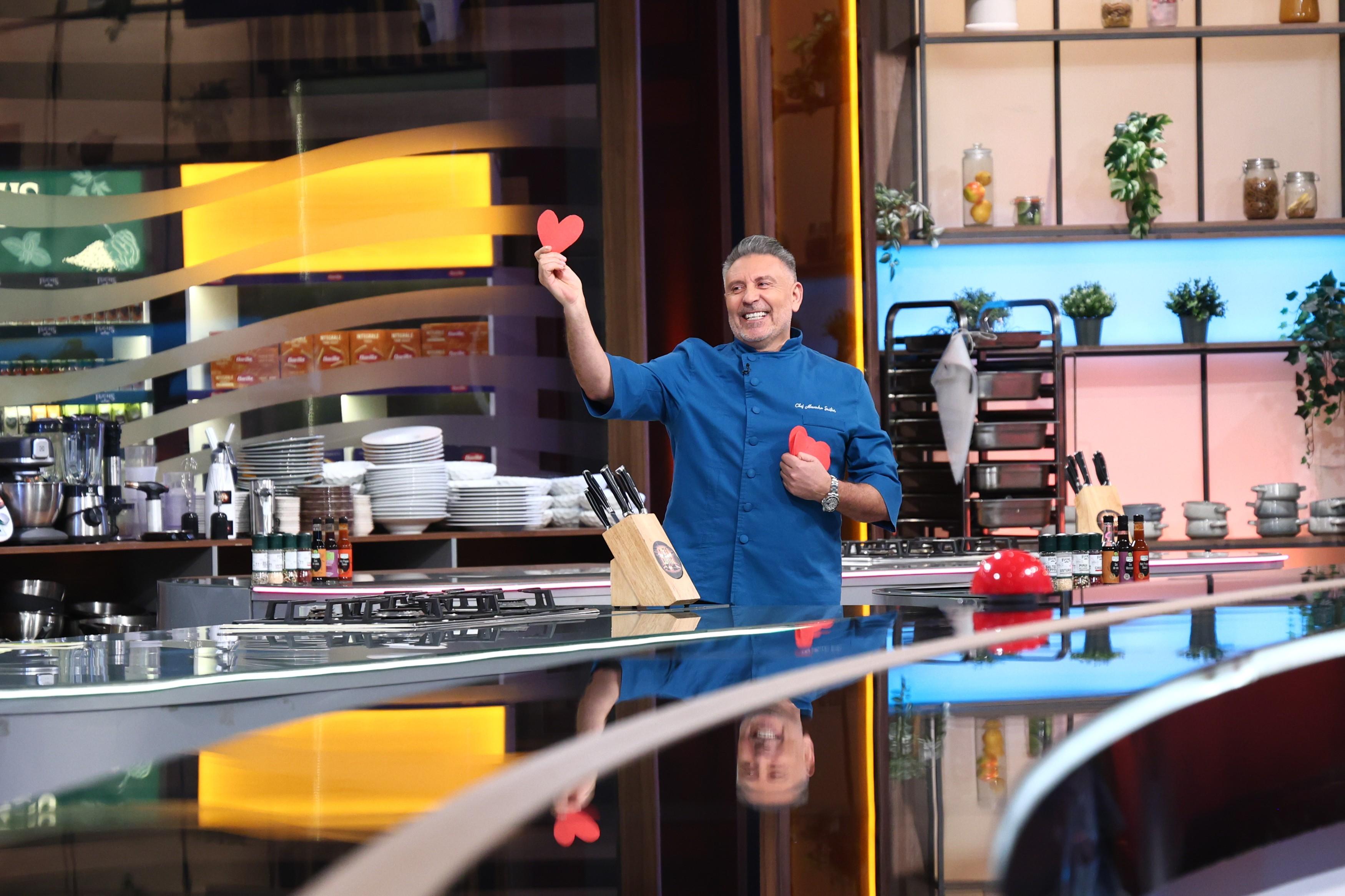 Chef Alexandru Sautner cu o inimă roz din hârtie în mână