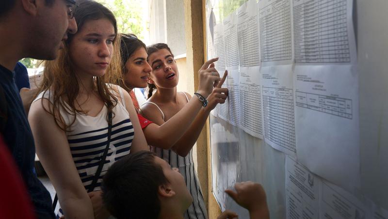 imagine cu elevi care isi cauta rezultatele la evaluarea nationala